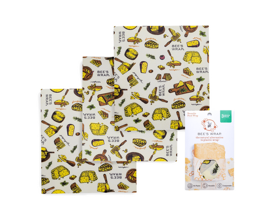 Three reusable Medium Bees Wraps with Wheels n Wedges print pattern are displayed next to their paper packaging on a solid white background.